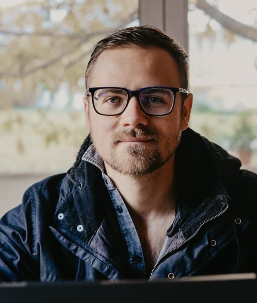 David Sampson with his glasses on, sitting at his laptop